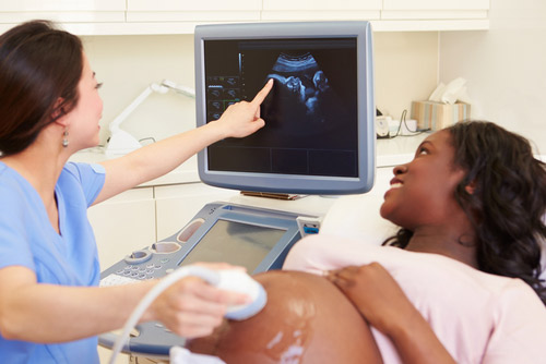 Technicien en échographie de Floride effectuant un sonogramme sur une patiente enceinte